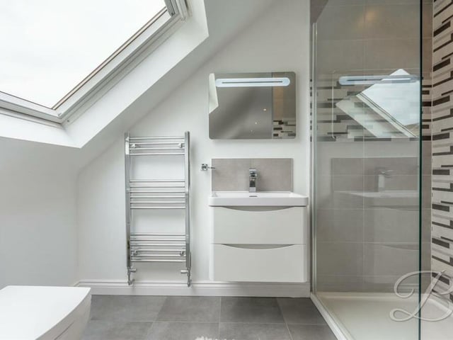 We complete our look at the interior of the Huthwaite property in the en suite shower room to the final bedroom. It consists of a walk-in shower cubicle, vanity hand wash basin, low-flush WC, chrome, heated towel-rail and Velux window.