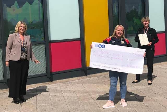 Danii Poulter, club captain at Ashfield Rugby Club, presenting the cheque to staff at King's Mill Hospital
