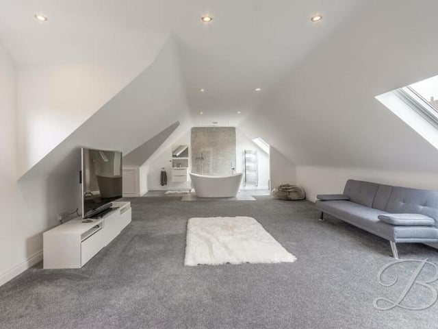 This is the master bedroom from a different angle. There is room for a sofa and TV and at one end of the vast space is an open bathroom area.