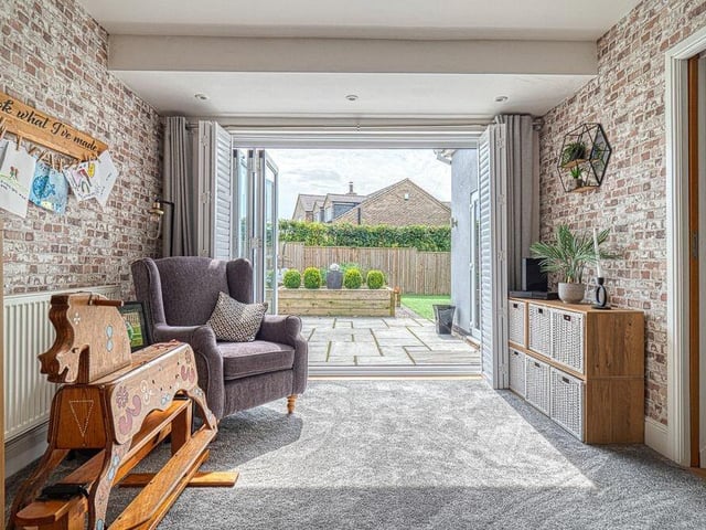 This is another reception room that can be used as a home office or even a playroom for the kids, Either way, it has a newly-fitted carpet and bi-folding doors to the garden courtyard. At the opposite end are the stairs to the first floor.