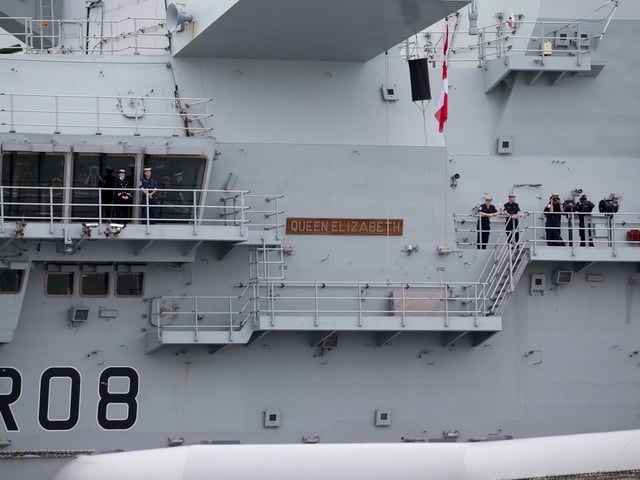 Crew members stand outside as HMS Queen Elizabeth leaves Portsmouth on September 9. Picture: Andrew Matthews/PA Wire