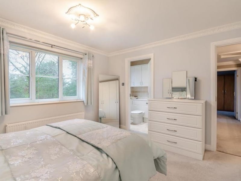 This second shot of the master bedroom shows doors leading to and from both the landing and an en suite bathroom.