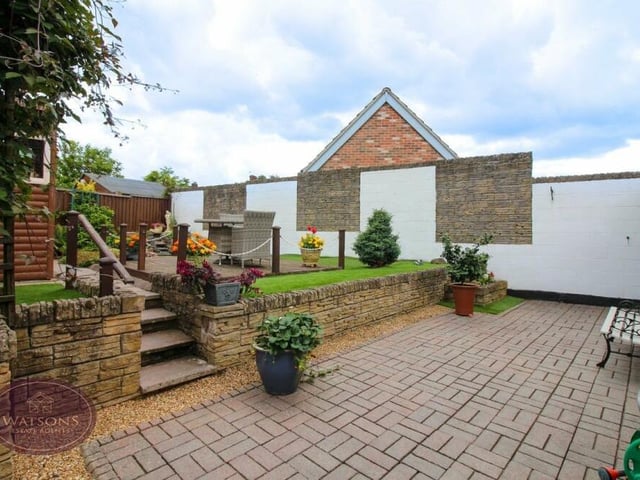 The rear garden is enclosed by a wall and timber fencing, ensuring a high level of privacy.