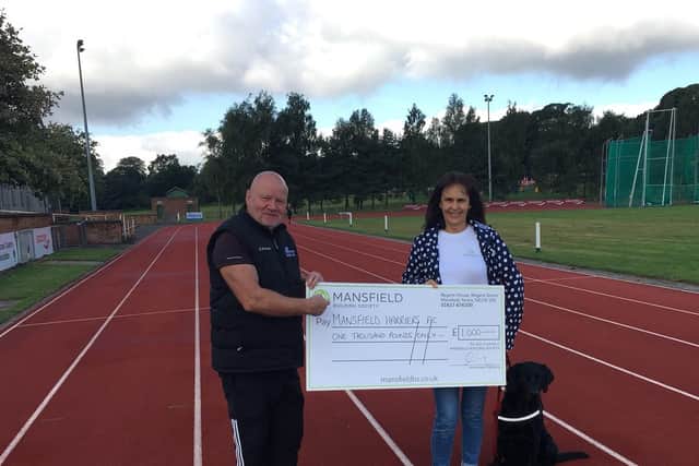 Pat Carlan, Chairman of Mansfield Harriers, receives the presentation cheque from Mandy Whitten, Products Coordinator for Mansfield Building Society