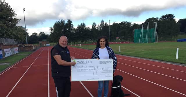 Pat Carlan, Chairman of Mansfield Harriers, receives the presentation cheque from Mandy Whitten, Products Coordinator for Mansfield Building Society