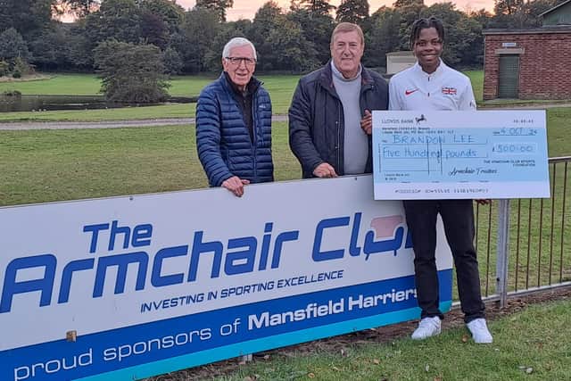 Brandon Lee is presented with a cheque by Armchair Club members Geoff Waller and Stewart Rickersey at the Berry Hill track, the home of Mansfield Harriers.