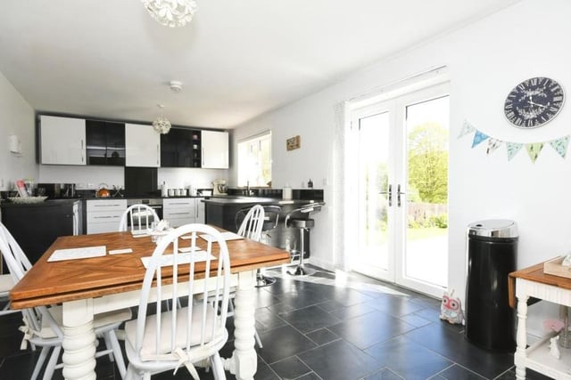 As we step into the property, the entrance hallway leads straight into this stylish fitted kitchen. As you can see, there is plenty of room for a breakfast or dining table, while the double doors lead out to the garden.