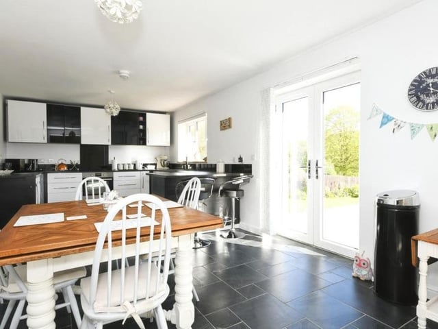 As we step into the property, the entrance hallway leads straight into this stylish fitted kitchen. As you can see, there is plenty of room for a breakfast or dining table, while the double doors lead out to the garden.