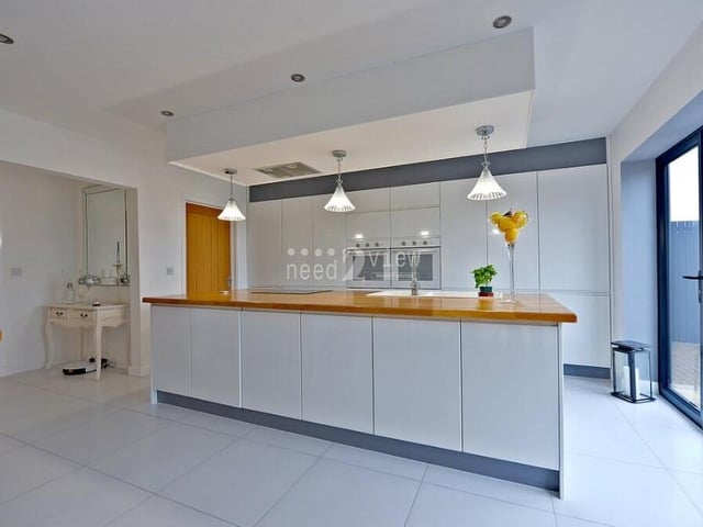 A closer look at the kitchen, where integrated appliances include a fridge freezer, double oven and hob with extractor fan over.