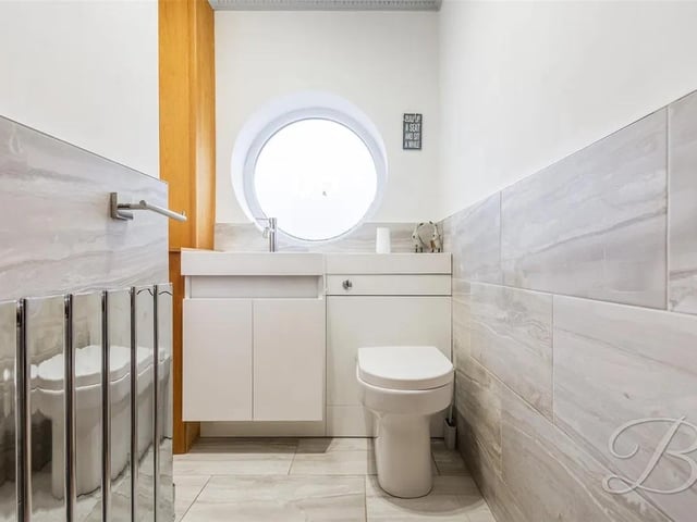 Fitted with a low flush WC, hand wash basin and a window to the front elevation.