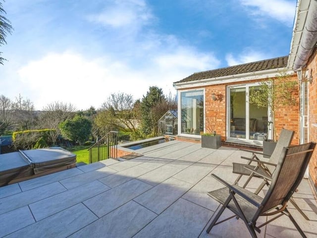 One of the highlights of the garden, rising above the lawn, is this slabbed patio, with seating area, and also an integral, fully functioning pond.