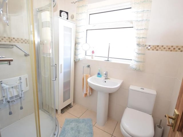 Here is the first of two shower rooms at the Ravenshead dormer bungalow. It's on the ground floor and features a shower cubicle, low-flush WC and wash basin, with tiled floor and walls.