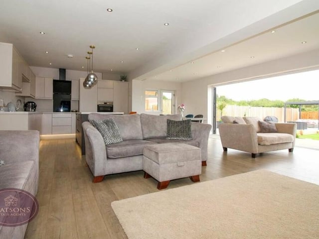 The living area or lounge, which has a wood-effect laminate floor and ceiling spotlights, is given a thoroughly open outlook by the large bi-folding doors.