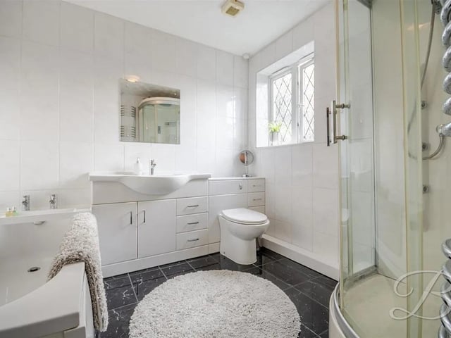 The main bathroom is stylishly appointed, designed to meet the needs of a busy household while maintaining a modern and elegant feel.
