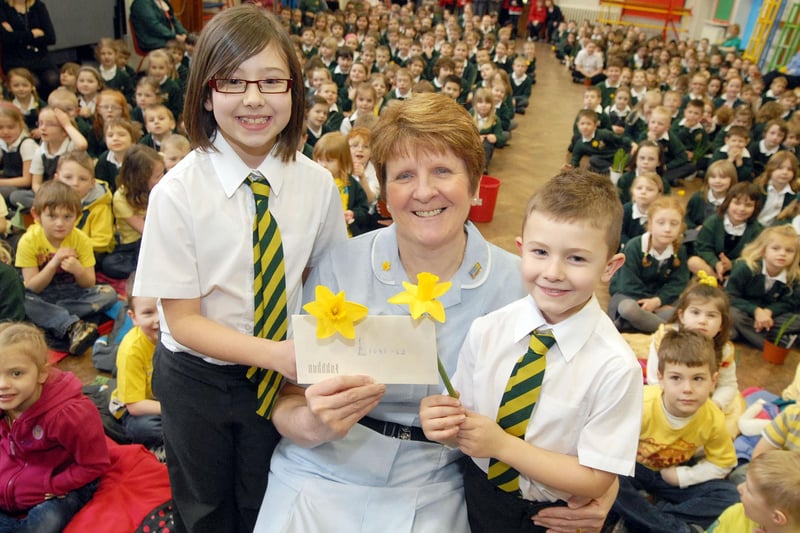 Molly and Harry Thomas, both pupils at High Oakham Primary School, present the money collected so far from their daffodil growing challenge totalling £1,085.62 to Marie Curie nurse Carolyn Clarke.  The presentation was made in 2011 in a special assembly for the young growers who all brought in examples of their work.