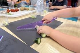 Children learning how to prepare and chop vegetables safely