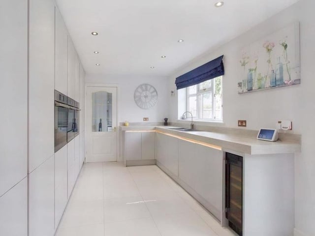 The kitchen is sleek and socially styled. Spotlighting and recessed lighting in the base and wall units provide clear illumination for all your slicing and dicing. Integrated appliances include a wine cooler.