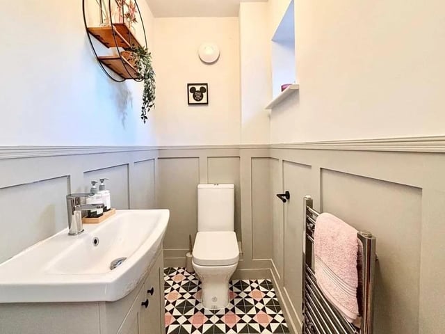 The convenient WC is located to the ground floor with stylish flooring, panelling, vanity wash basin and WC.