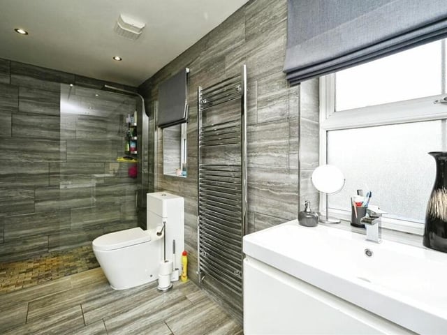This second shot of the refitted family bathroom shows its walk-in shower cubicle with shower screen. It contains a standard shower, a waterfall shower, a hand-held shower and jets.