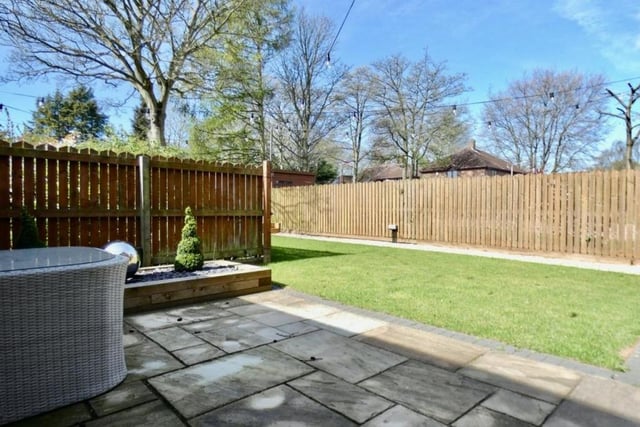 The first of four photos of the back of the Forest Town property. A landscaped, enclosed garden boasts this patio area.
