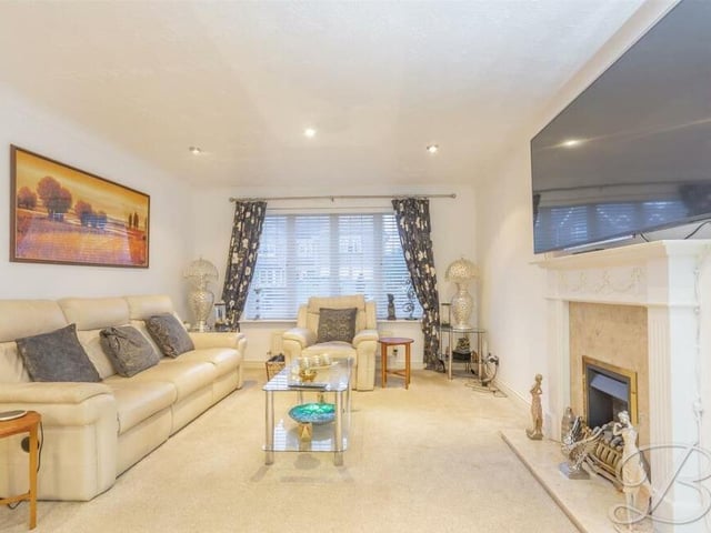 A second shot of the beautifully presented lounge, with its fitted carpets, downlights and large window overlooking the front of the property.