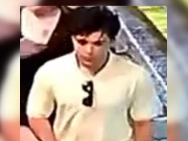 Man, white t-shirt, sunglasses attached to t-shirt, jeans.