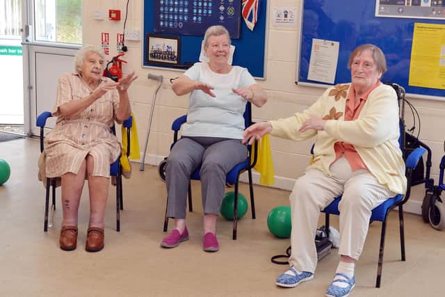 Nina (left) and her friends taking part in chair-based exercise as part of Friendship Group, which she attends three days a week.