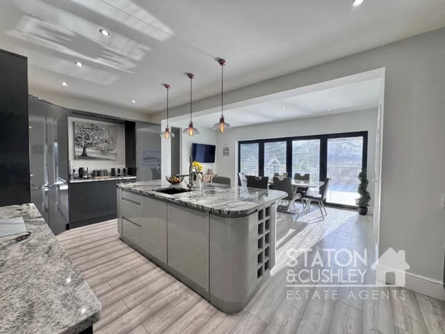The open plan kitchen/lounge/diner boasting a range of modern wall and base units, central island and integrated appliances including full length fridge and freezer, dishwasher, wine cooler, coffee machine and microwave/oven providing all you need and more to cook up tasty dishes.
