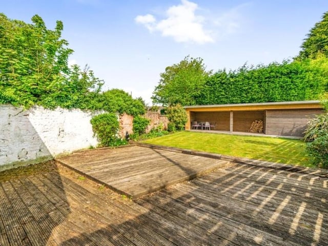 Beyond the decking area and lawn in the garden of the £500,000 Willow Cottages property is a splendid, covered sun deck