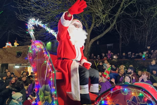 Santa waves to the crowd as he arrives with the sleigh procession