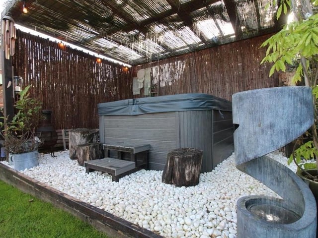 The extraordinary rear garden also boasts this covered pergola, which is the ideal space to house a hot tub.