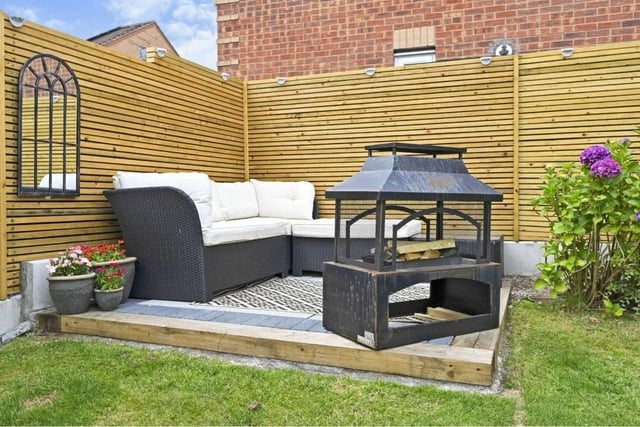 This charming corner of the garden has been turned into a tasteful seating area, with barbecue if required.