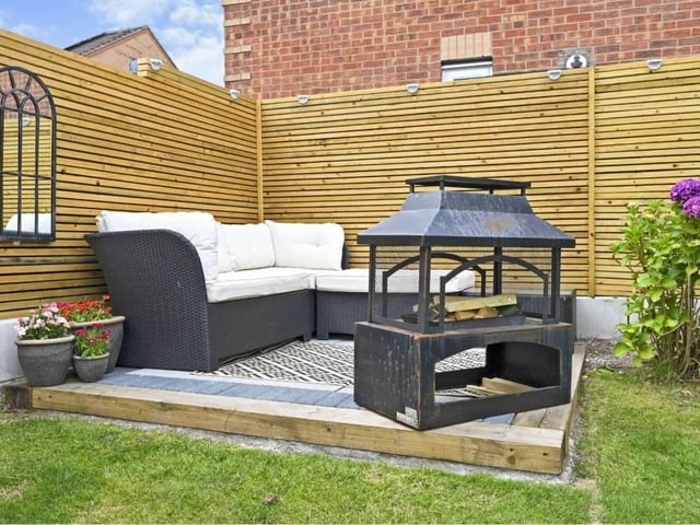 This charming corner of the garden has been turned into a tasteful seating area, with barbecue if required.