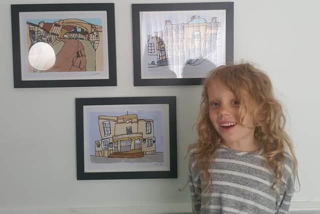 Chloe Wright, 6 with her drawings.