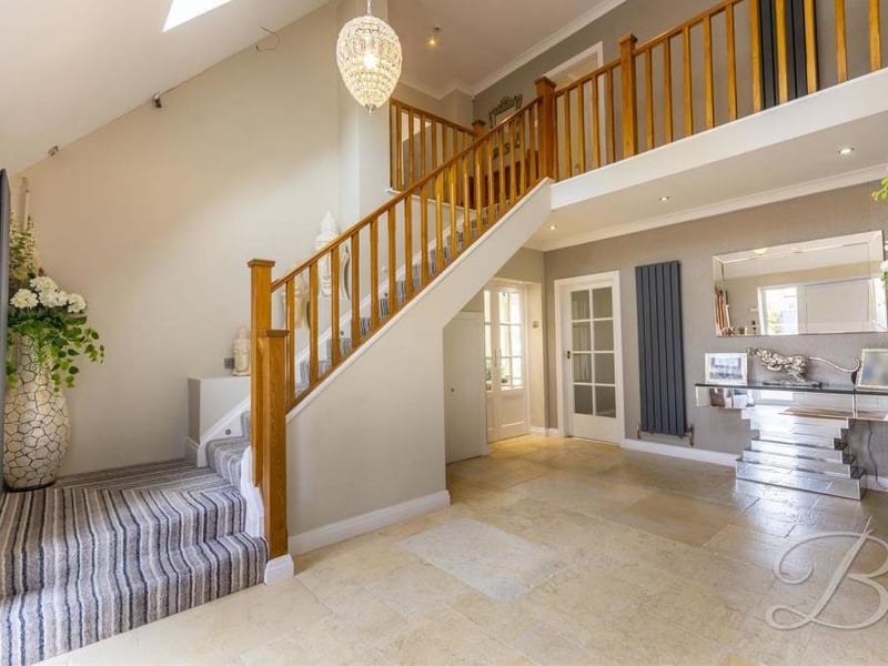 The striking staircase that leads to the first floor. Both the hallway and the landing house cupboards for additional storage.