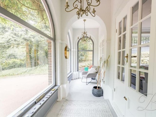 Here is the sun room, accessed via French doors from the living room (right). Feature arch windows give glorious views of the garden.