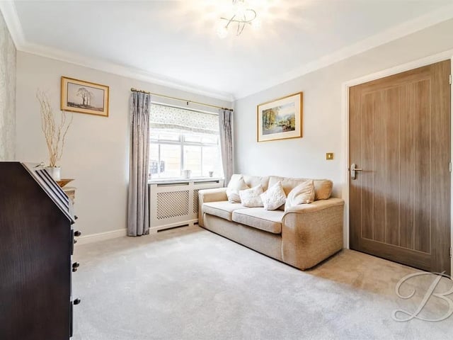 The lounge features comfortable carpeted flooring and a front-facing window that fills the space with natural light, offering a cosy spot to relax.