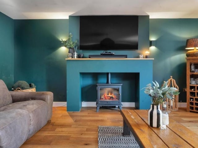 A focal point of the lounge is this charming feature fireplace with inset electric log-burner.