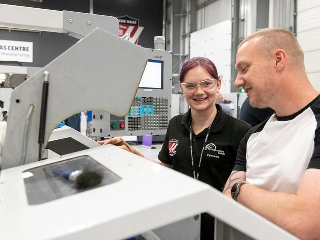 Engineering student Sian Moss (left) explains how to use a Haas CNC lathe.