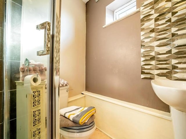 Here is the en suite to the main bedroom, complete with shower cubicle, WC, wash hand basin, extractor fan and tiled flooring.