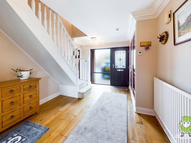 As we prepare to go upstairs to check out the bedrooms, let's step in to the hallway, which is warm and welcoming, with space for storage.