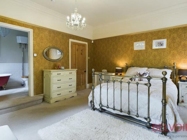 The charming primary bedroom from a different angle, showing how it has access to an en suite bathroom.