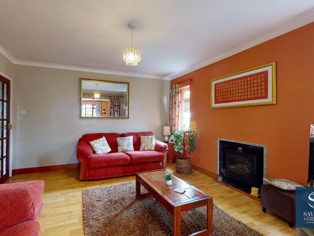 A focal feature of the lounge is a gas living flame log-burning stove, either side of which are uPVC double-glazed windows. The floor is laminated and there is coving to the ceiling.