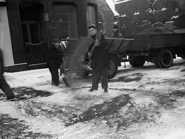 Workmen scattering grit on Jeffrey Street in 1960.