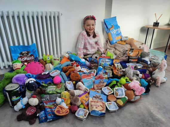 Madeleine Riley, seven, surrounded by the dozens of doggy donations she’s received.