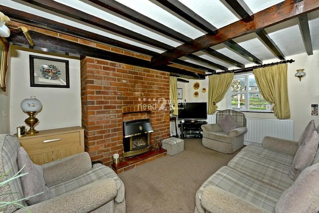 We launch our tour of Cosy Cottage in the lounge or living room, which is full of character thanks largely to its ceiling beams and bare-brick feature fireplace. It's a spacious family room with windows to the front and side.