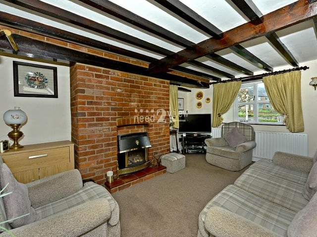 We launch our tour of Cosy Cottage in the lounge or living room, which is full of character thanks largely to its ceiling beams and bare-brick feature fireplace. It's a spacious family room with windows to the front and side.
