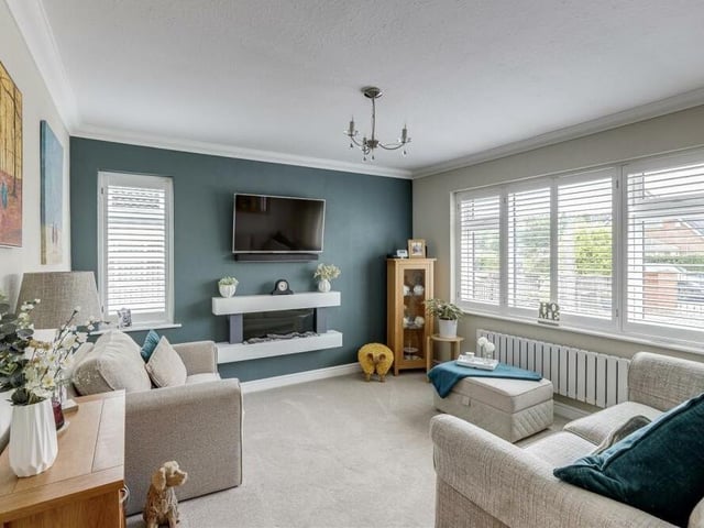 Here is the attractive living room, which exudes comfort and style, especially with its wall-mounted, electric flame-effect feature fireplace. There is also a carpeted floor, coving to the ceiling and column radiator.