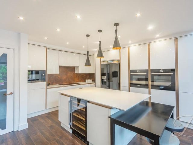 From the lounge, we move into the contemporary kitchen, which boasts space and style in abundance. It is fitted with sleek wall and base units, integrated appliances and a centre island with breakfast bar.