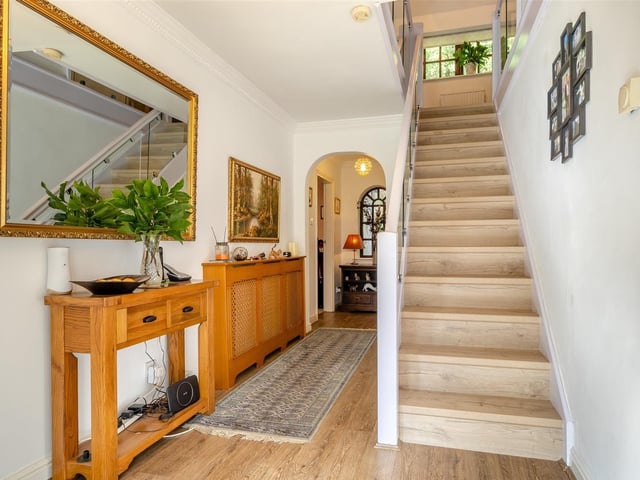 As we prepare to go upstairs, let's return to the hallway to climb a beautifully appointed bespoke oak and glass staircase.